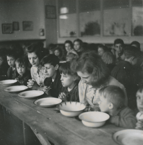 876781 Afbeelding van een grote groep kinderen die gaan eten in een klaslokaal van de Piusschool (Oudegracht 33) te ...